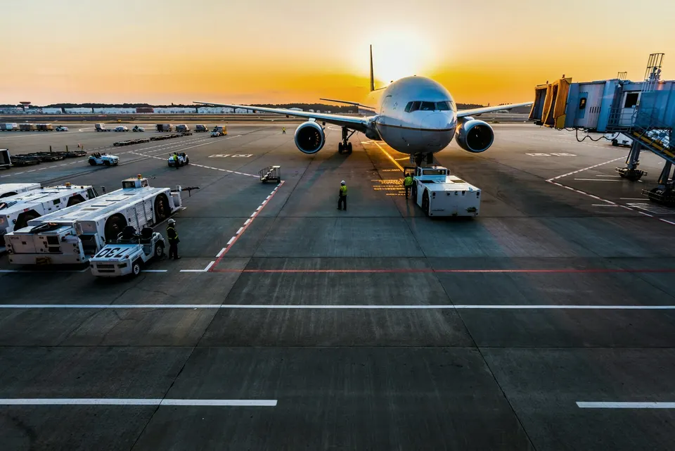 Cargo aircraft on the airport apron at sunrise, being loaded
